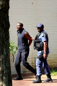 Chatunga Berllamine Mugabe Arrested In South Africa, in handcuffs being taken away by SAPS police over attempted murder charge. 